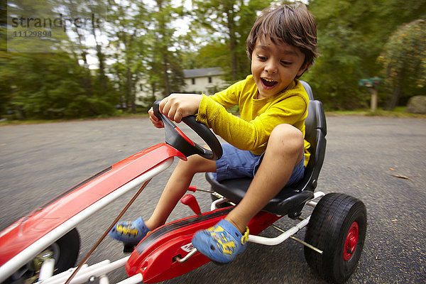 Gemischtrassiger Junge fährt Spielzeugauto