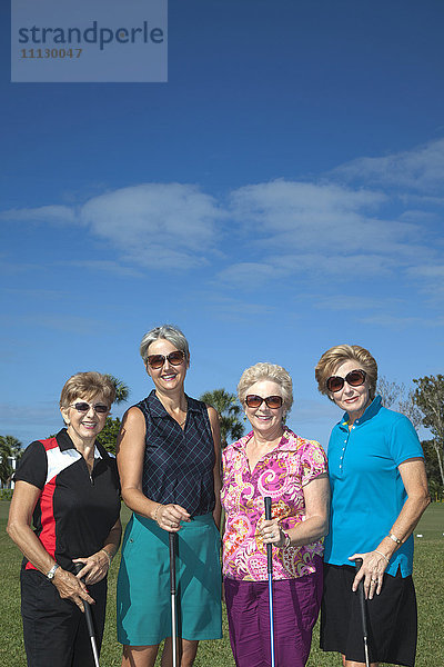 Ältere kaukasische Frauen beim Golfspielen