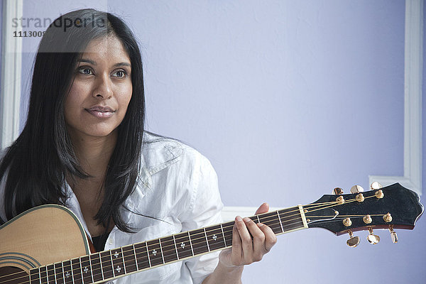 Sri Lankische Frau spielt Gitarre