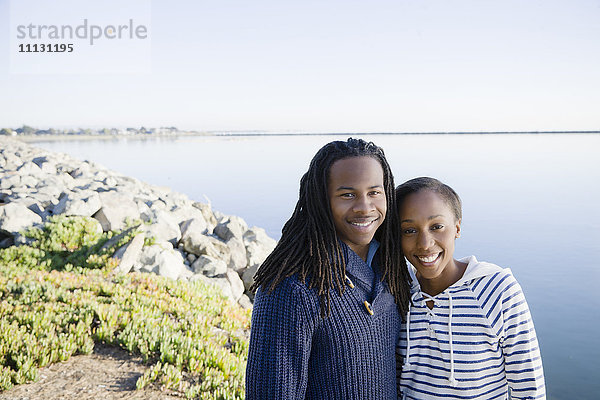 Schwarzes Paar  das sich in der Nähe der Bucht umarmt