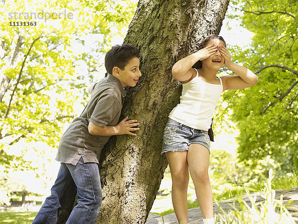 Gemischtrassiger Bruder und Schwester spielen Verstecken