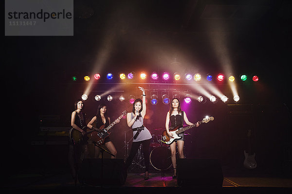 Asiatische Frauen  die auf der Bühne singen und E-Gitarre spielen