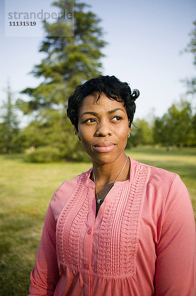 Schwarze Frau im Park stehend