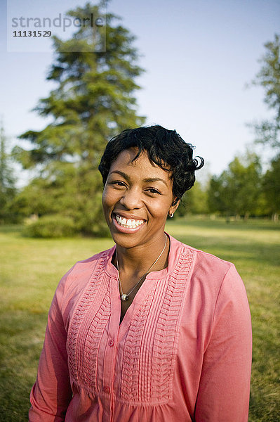 Lächelnde schwarze Frau im Park stehend