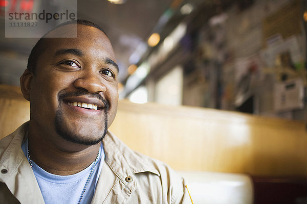 Afrikanischer Mann lächelt im Diner