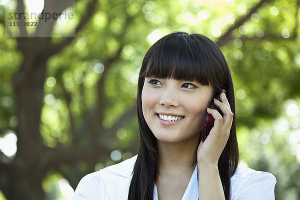 Asiatische Frau telefoniert mit Handy