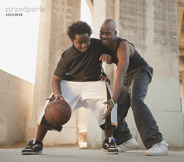 Afrikanischer Vater spielt Basketball mit seinem Sohn