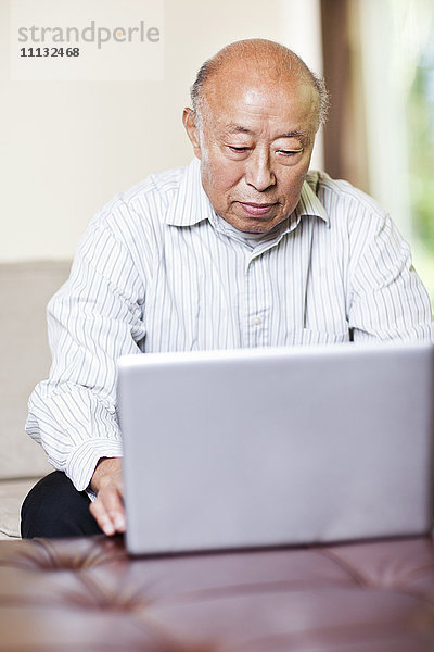 Chinesischer Mann mit Laptop
