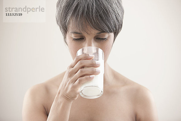 Gemischtrassige Frau trinkt Milch