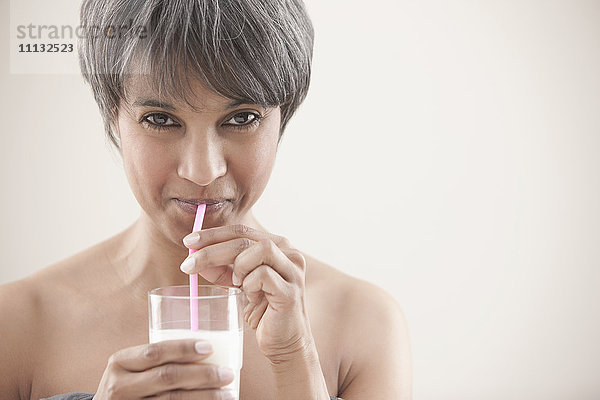 Gemischtrassige Frau trinkt Milch
