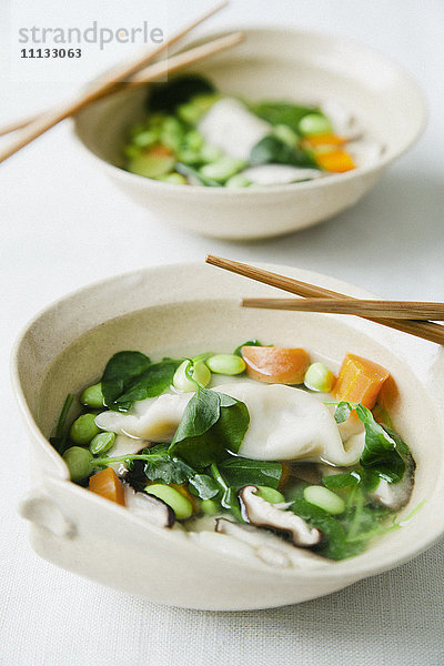 Asiatische Gemüsesuppe in Schalen mit Stäbchen
