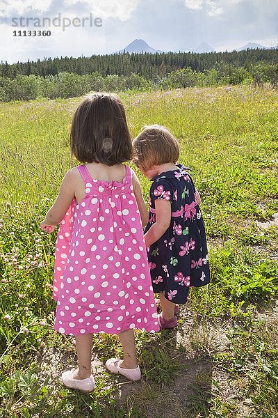 Mädchen gehen zusammen auf einem Feld