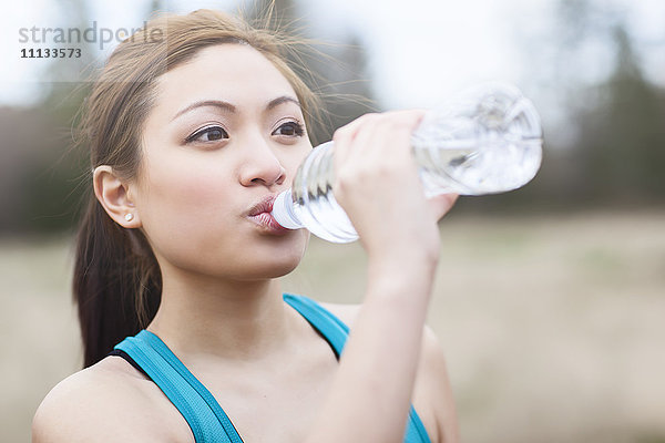 Asiatische Frau trinkt Wasser