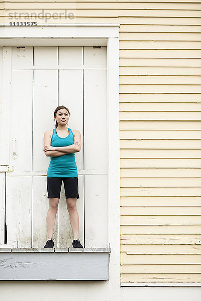 Asiatische Frau in Sportkleidung auf der Laderampe stehend