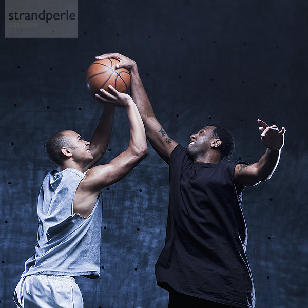 Männer spielen Basketball