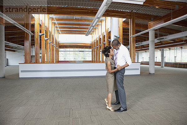 Paar tanzt in leerem Büroraum