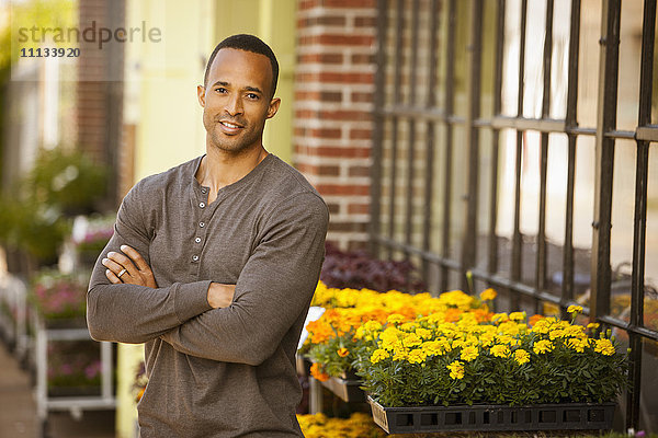 Afroamerikanischer Mann steht in der Nähe eines Blumenladens