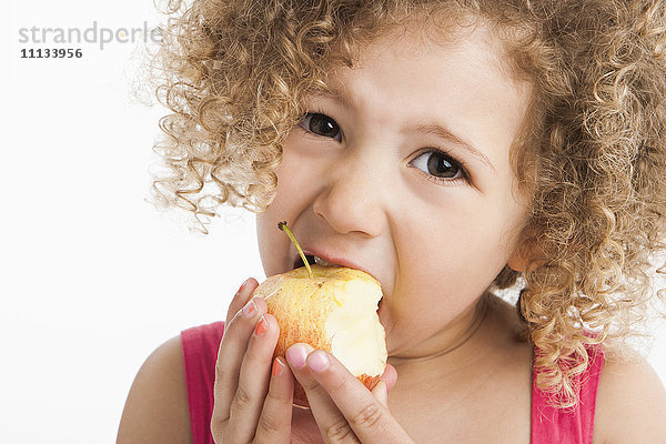 Gemischtrassiges Mädchen isst Apfel