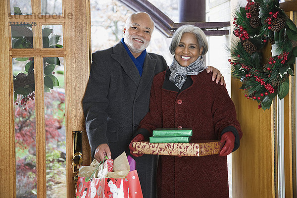 Ein afroamerikanisches Paar kommt mit Weihnachtsgeschenken an