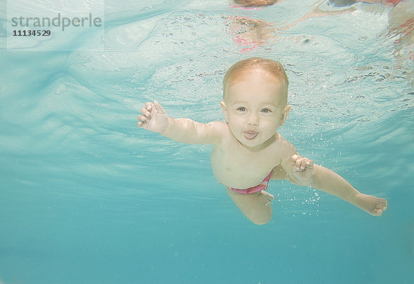 Kaukasisches Baby schwimmt unter Wasser