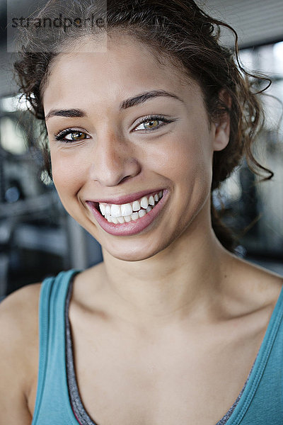 Lächelnde gemischtrassige Frau im Fitnessstudio