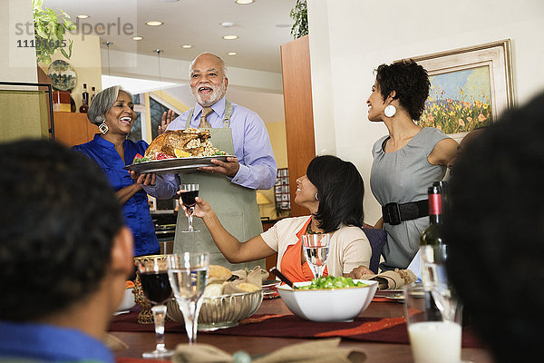 Afroamerikanischer Mann serviert Thanksgiving-Truthahn