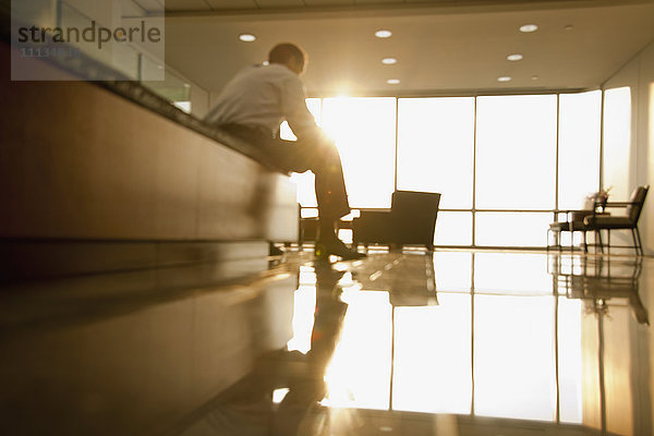 Gemischtrassiger Geschäftsmann sitzt in der Lobby