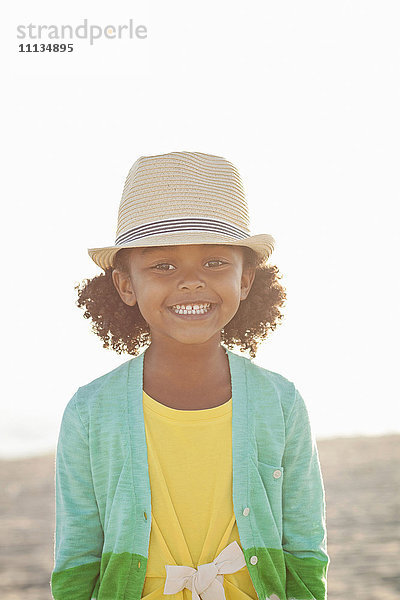 Lächelndes gemischtrassiges Mädchen am Strand