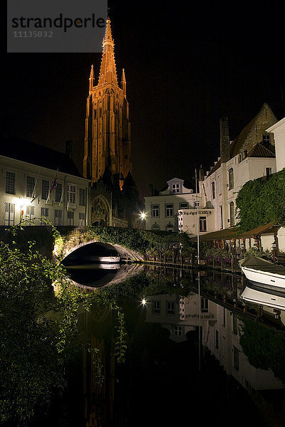 Kirche und Gebäude entlang des Kanals bei Nacht