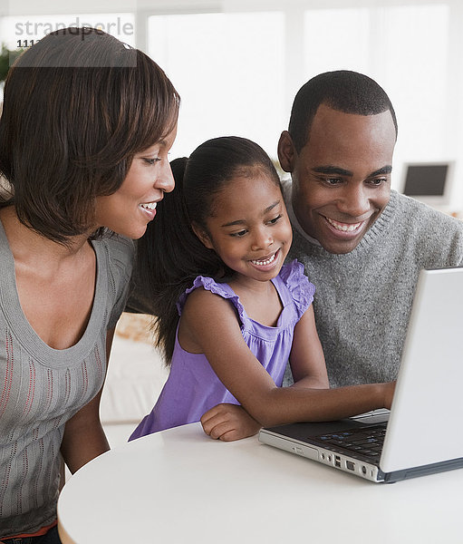 Afroamerikanische Familie benutzt gemeinsam einen Laptop
