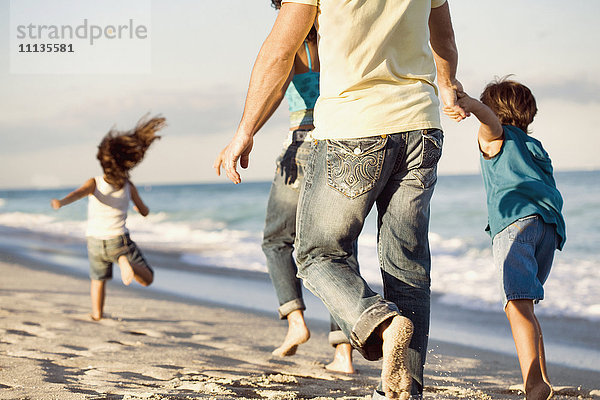 Familie läuft am Strand