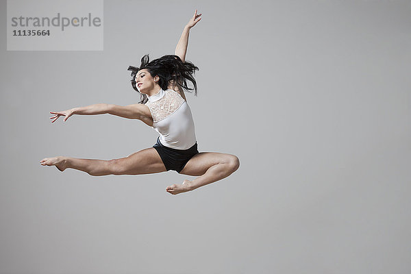 Anmutige kaukasische Balletttänzerin in der Luft