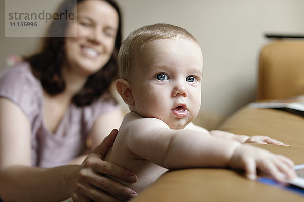 Kaukasische Mutter  die einen kleinen Jungen unterstützt