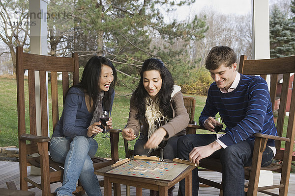 Freunde spielen Scrabble auf der Veranda