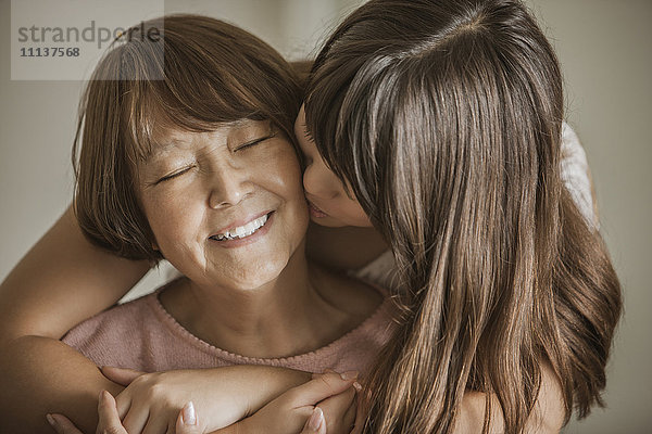 Frau küsst Großmutter