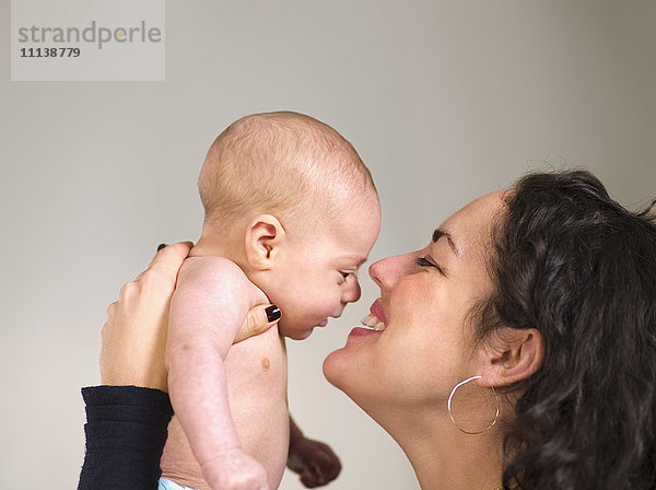 Mutter hält neugeborenes Baby von Angesicht zu Angesicht