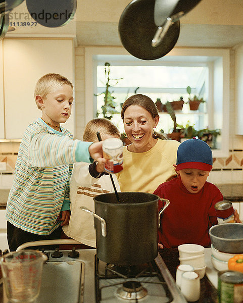 Kaukasische Mutter und Söhne bereiten Essen zu