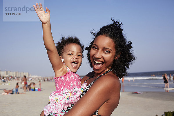 Gemischtrassige Mutter und Tochter genießen den Strand