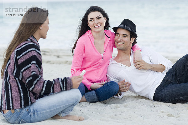 Freunde entspannen gemeinsam am Strand