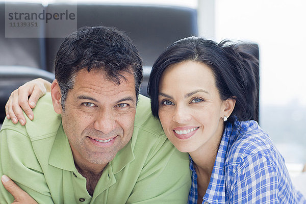Hispanisches Paar lächelnd im Wohnzimmer
