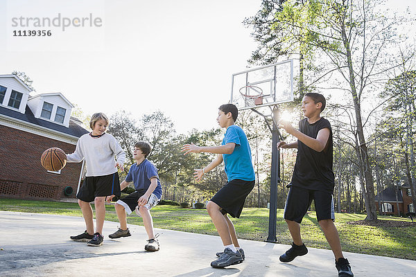 Jungen spielen Basketball