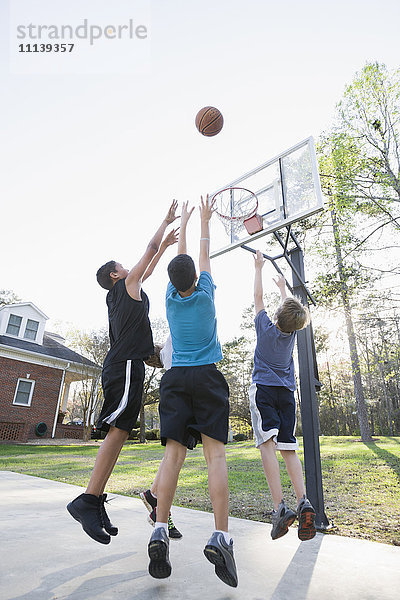 Jungen spielen Basketball