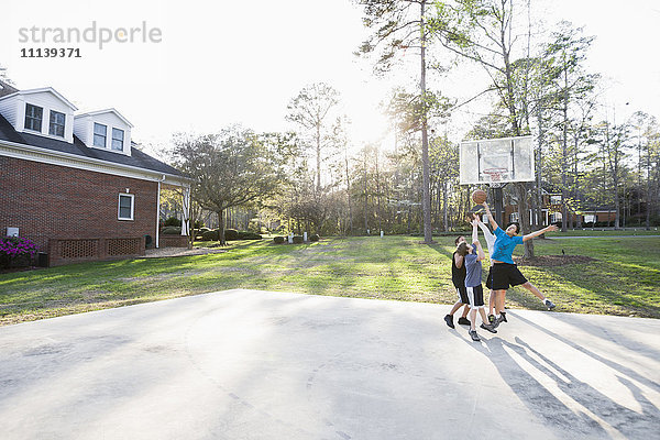 Jungen spielen Basketball