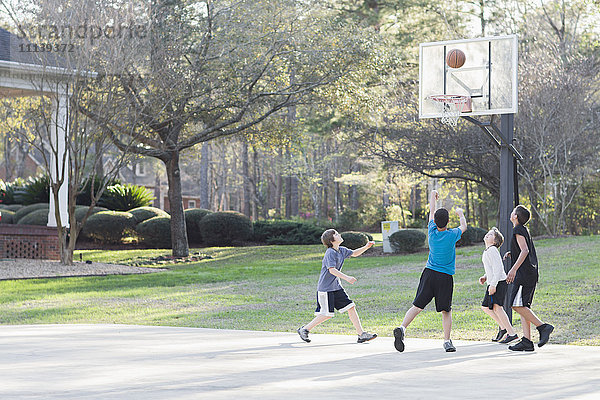 Jungen spielen Basketball