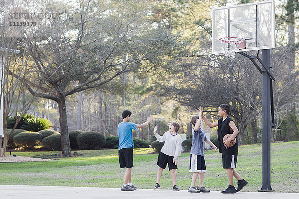 Jungen spielen Basketball