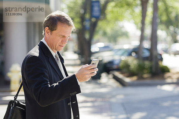 Kaukasischer Geschäftsmann mit Mobiltelefon