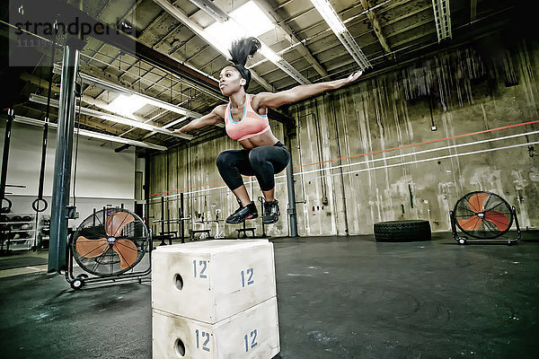 Gemischtrassige Frau beim Training im Fitnessstudio