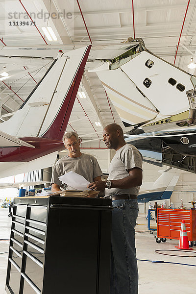 Männer arbeiten in einem Flugzeughangar