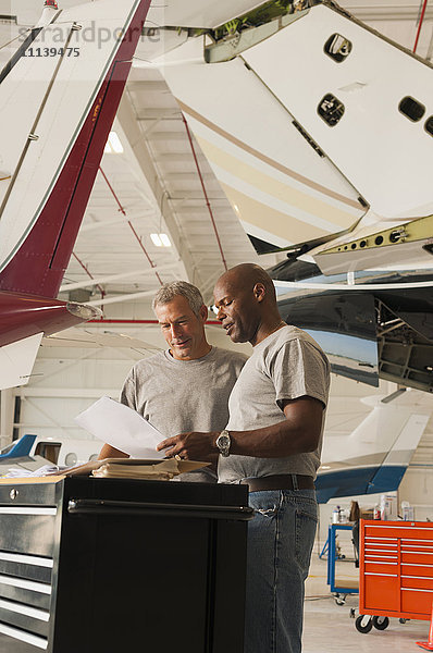 Männer arbeiten in einem Flugzeughangar