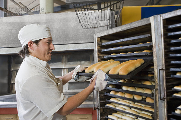 Spanischer Bäcker hält Tablett mit Brot